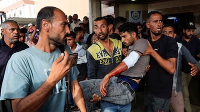 A Palestinian man injured in an Israeli strike while waiting for aid is carried into Nasser hospital, in Khan Younis, southern Gaza. Reuters