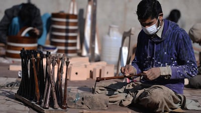 A Pakistani worker polishes a component to be used to make a set of bagpipes at the Mid East bagpipe factory. AFP.