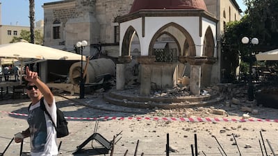 A man gestures in front of the toppled minaret of a mosque after an earthquake in Kos, Greece. Michael Probst / AP Photo