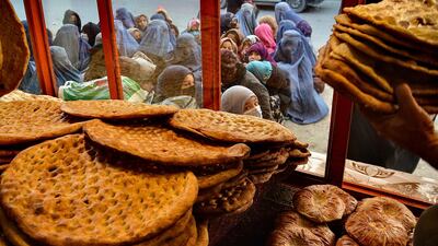 Afghan women and girls gather outside a Kabul bakery for food on February 19. AFP