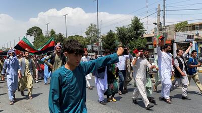 People carrying the national flag march in Kabul. Reuters