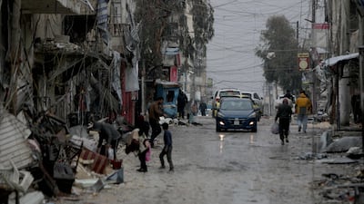 People walk down a street as a car drives by following the ceasefire. AFP