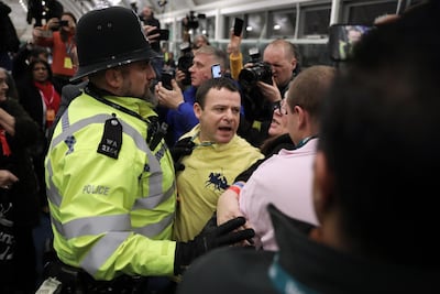 UXBRIDGE, ENGLAND - DECEMBER 12: A police officer breaks up a fight while Hayes and Harlington MP John McDonnell speaks at the vote declaration after retaining his seat on December 12, 2019 in Uxbridge, England. Exit polls predicted Prime Minister Boris Johnson will emerge from this general election with a governing majority, his aim when he called the first UK winter election for nearly a century. Election results from across the country are being counted overnight and an overall result is expected in the early hours of Friday morning. (Photo by Dan Kitwood/Getty Images)
