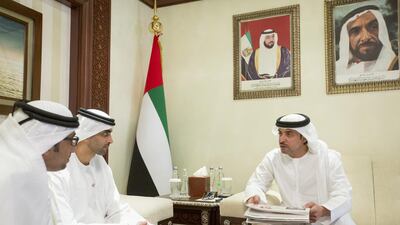 Sheikh Hazza bin Zayed, right, discusses the newly designed Al Ittihad with Mohamed Al Mahmood, chairman and managing director of Abu Dhabi Media, centre, and Mohammed Al Hammadi, editor-in-chief of the newspaper. Ryan Carter / Crown Prince Court – Abu Dhabi