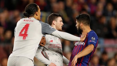 Liverpool's Virgil van Dijk and Andrew Robertson clash with Barcelona's Suarez. Action Images