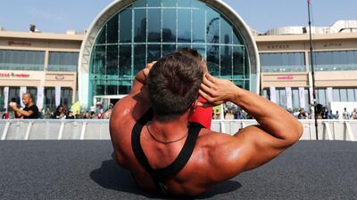 Dozens of people take part in an aerobics class on the field at Dubai Festival City. Chris Whiteoak / The National