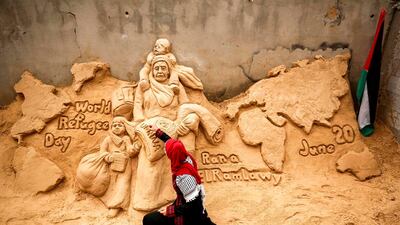 Palestinian sand sculptor Rana Ramlawi finishes a new artwork creation commemorating World Refugee Day, a day dedicated by the United Nations General Assembly to raising awareness of the situation of refugees throughout the world, in Gaza City, depicting a woman carrying a child and a sack of flour bearing the logo of the United Nations Relief and Works Agency for Palestine Refugees (UNRWA) with a child behind holding a jerry can of water, all standing before a map of the world. Nearly one-third of refugees registered by the UNRWA, more than 1.5 million individuals, live in 58 recognised refugee camps in the Gaza Strip and the West Bank including East Jerusalem, in addition to Jordan, Lebanon, and Syria. AFP