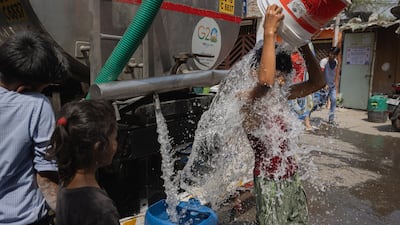A boy cools himself with water from the New Delhi Municipal Council tanker during India's summer heatwave. Getty Images