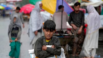 An Afghan child seeks shelter at the old market in Kabul. AP