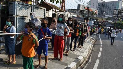 People queue up to buy low-cost rice and chicken packages to break their fast during the holy month of Ramadan in Bandung. AFP