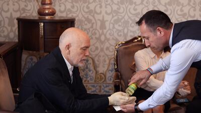 An Istanbul municipality employee pours cologne in the hands of actor John Malkovich during a meeting with the city's mayor, Ekrem Imamoglu, in Istanbul. AP