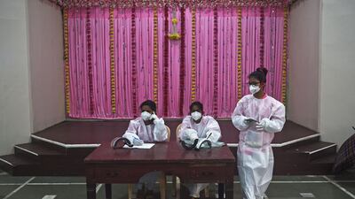 Medical volunteers wait to register people for coronavirus tests at a marriage hall temporarily converted into a testing centre, in Mumbai on July 17, 2020. AFP