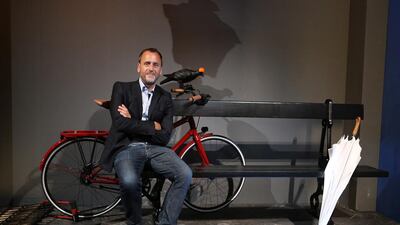 Wanderland scenographer Hubert Le Gall sits in a street scene, with an umbrella and a bicycle. The pigeon sitting on the bike’s handle bars while wearing a tiny Hermes crash helmet — a detail specifically created for Dubai — is an example of the playful attention to detail that has been paid. Pawan Singh / The National