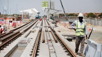 Workers lay tracks and build a station near Dubai Media City for the project. The trams are being manufactured in France.