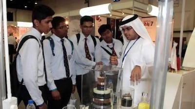 Sultan Al Kendi, an engineer with the plastics company Borouge, chats to students during the Think Science contest in Dubai yesterday. Jeffrey E Biteng / The National