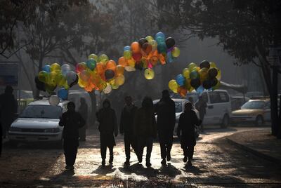 Afghan balloon vendors walks past the Ministry of Public Works a day after a deadly militant attack in Kabul on December 25, 2018. AFP