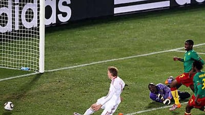 Denmark's Nicklas Bendtner, left, scores the equaliser against Cameroon.