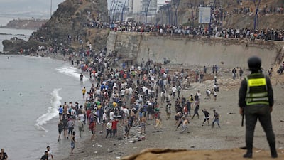 People gather along the fence at the site of clashes near Fnideq, on the Morocco-Spain border. AFP