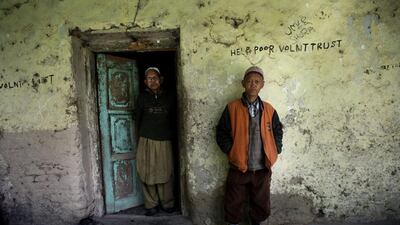 Patients stand in front of one of the huts.
