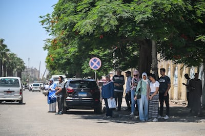 Egyptians stand under the shade of a tree in Cairo, Egypt, during a heatwave in early June. EPA
