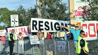 Protestors hold signs and banners against Donald Trump after his arrival in West Palm Beach, Florida on April 18, 2019. AFP