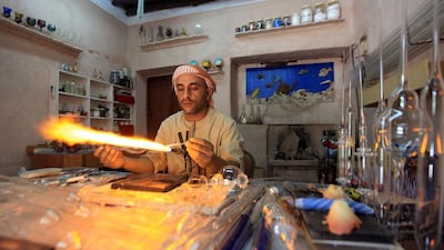Noor Ahmed showing his glass blowing work skills to tourist at Emirates Heritage village on the Corniche in Abu Dhabi. Ravindranath K / The National