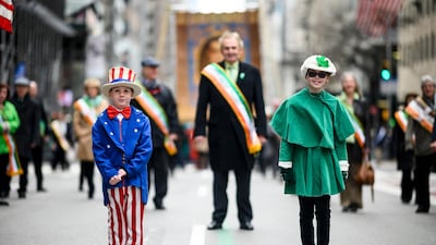 A boy dressed as 'Uncle Sam' and a girl dressed in all green make their way up 5th Avenue during the annual New York City St. Patrick's Day parade in 2019. AFP