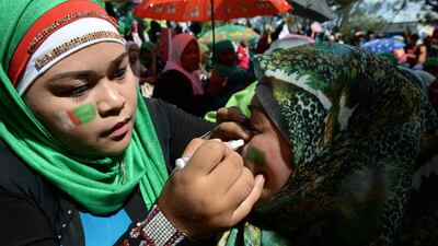 A Muslim woman paints the flag of the Moro Islamic Liberation Front on her mother during a rally in support of the peace agreement with the government in Cotabato City, on the southern island of Mindanao, on March 27, 2014. Ted Aljibe / AFP