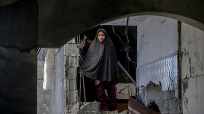 A Palestinian woman inspects her family's destroyed house following an Israeli air strike on Deir Al Balah refugee camp in central Gaza on Wednesday. EPA