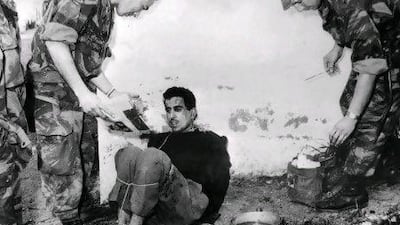 French paratroopers question Algerian Merouane Omar at St. Eugene in Algeria on March 14, 1957.