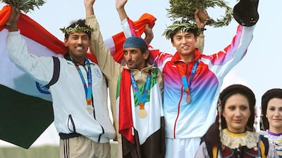 Sheikh Ahmed bin Hasher, centre, won the gold medal in the men's double trap event at the 2004 Athens Olympic Games. Getty Images