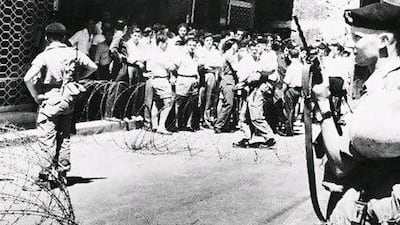 Men of the Royal Berkshire regiment stand guard at a barbed wire barricade in Ledra Street, Nicosia, where Cypriot civilians are gathered for questioning following the shooting of a British serviceman on September 1, 1958.