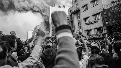 Troops loyal to Shah Mohammad arrive to control demonstrators outside a burning government building, at the height of Islamic revolutionary fervour in Tehran, on November 4, 1978. Getty Images