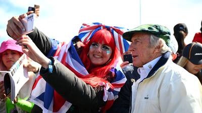 Sir Jackie Stewart signs autographs before entering the paddock. Getty