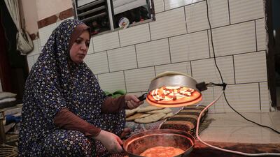 A Palestinian woman preparing bread during the few hours of mains electricity supply they receive every day, at Rafah refugee camp in the southern Gaza Strip.Said Khatib/AFP