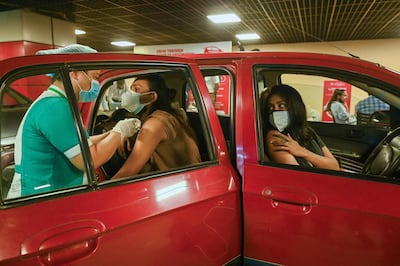 A health worker inoculates a man with Covaxin at a drive-in vaccination centre in New Delhi. AFP