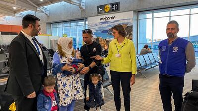 German ambassador to Cyprus Anke Schlimm with a family of asylum seekers, who are among 48 migrants being transferred to Germany, at the island's Larnaca International Airport. German Foreign Ministry / AFP
