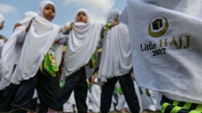 Hijab-clad Malaysian girls from the Little Caliphs kindergarten circumambulate a mockup of the Kaaba.