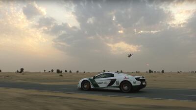A screen-grab from a video of a drone racing a Dubai Police McLaren 650s through Dubai. Courtesy World Drone Prix