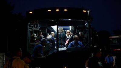 Festival attendees are whisked away from the scene on buses. AP