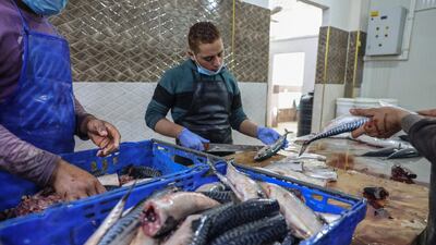 Palestinian youths prepare mackerels to be sold at a fish market before the Eid Al Fitr holiday, in the town of Rafah, in southern Gaza Strip. AFP
