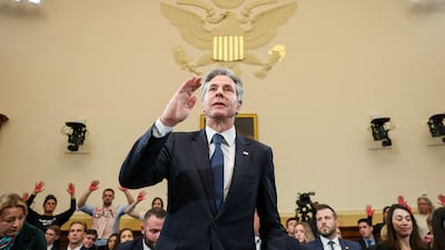 Protesters hold up red-painted hands as US Secretary of State Antony Blinken testifies at a House foreign affairs committee meeting on December 11. Getty Images via AFP