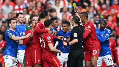 Referee Stuart Attwell shows a yellow card to Everton's French midfielder Abdoulaye Doucoure. AFP