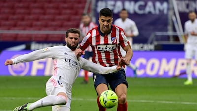 Real Madrid's Spanish defender Nacho Fernandez challenges Atletico Madrid's Uruguayan forward Luis Suarez. AFP
