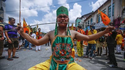 A Chinese devotee who has his cheeks pierced with a skewer sits on a chair before marching around Chinatown during the Guan Ping Festival in Kuala Lumpur June 8, 2014. The festival, held in celebration to mark the birthday of Chinese deity Guan Ping, is believed to bring prosperity for local businesses. Reuters