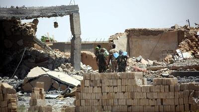 Fighters from the Syrian Democratic Forces walk through an area seized from ISIL in western Raqqa on June 11, 2017. Delil Souleiman / AFP