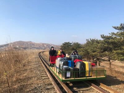 Russian diplomats and their families use a hand-pushed rail trolley to leave North Korea. Reuters