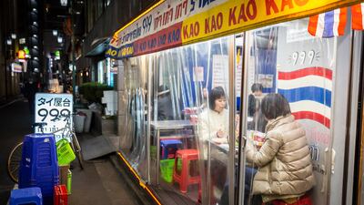 People enjoy meals and drinks in Tokyo, but restaurants and bars are to close early under new restrictions. Getty