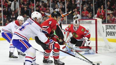 Niklas Hjalmarsson, right, of the Chicago Blackhawks battles for the puck with Tomas Plekanec of the Montreal Canadiens during their 4-3 win in the NHL on Friday. David Banks / USA Today Sports / December 5, 2014