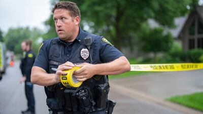 Brooklyn Park Police Lieutenant Hjelm sets up a perimeter with police tape near the scene of a shooting in Brooklyn Park, Minnesota. AP